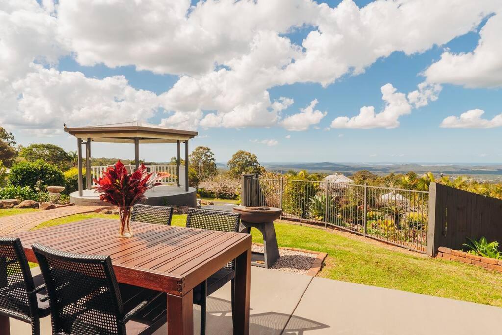 a wooden table and chairs on a patio with a gazebo at Stunning Home in Mt Mellum with Panoramic Coastal Views in Bald Knob