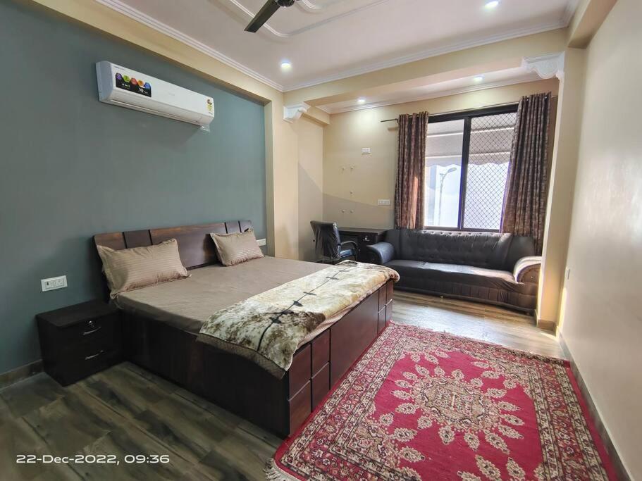 ein Schlafzimmer mit einem großen Bett und einem Sofa in der Unterkunft 4 Bedroom Luxury Independent floor, OSHO Villa, Jaipur Airport in Jaipur