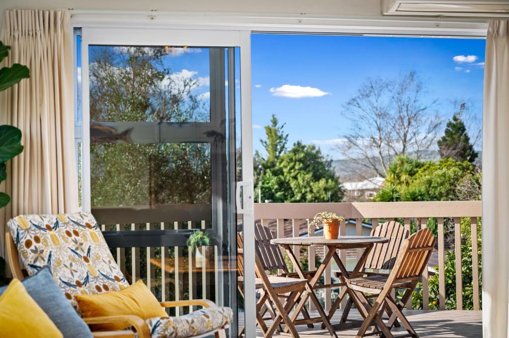 a patio with a table and chairs on a balcony at Rooftops Rotorua in Rotorua