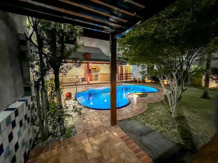 a swimming pool in the backyard of a house at Casa Paris 481 - Sua Mansão na Praia do Morro in Guarapari