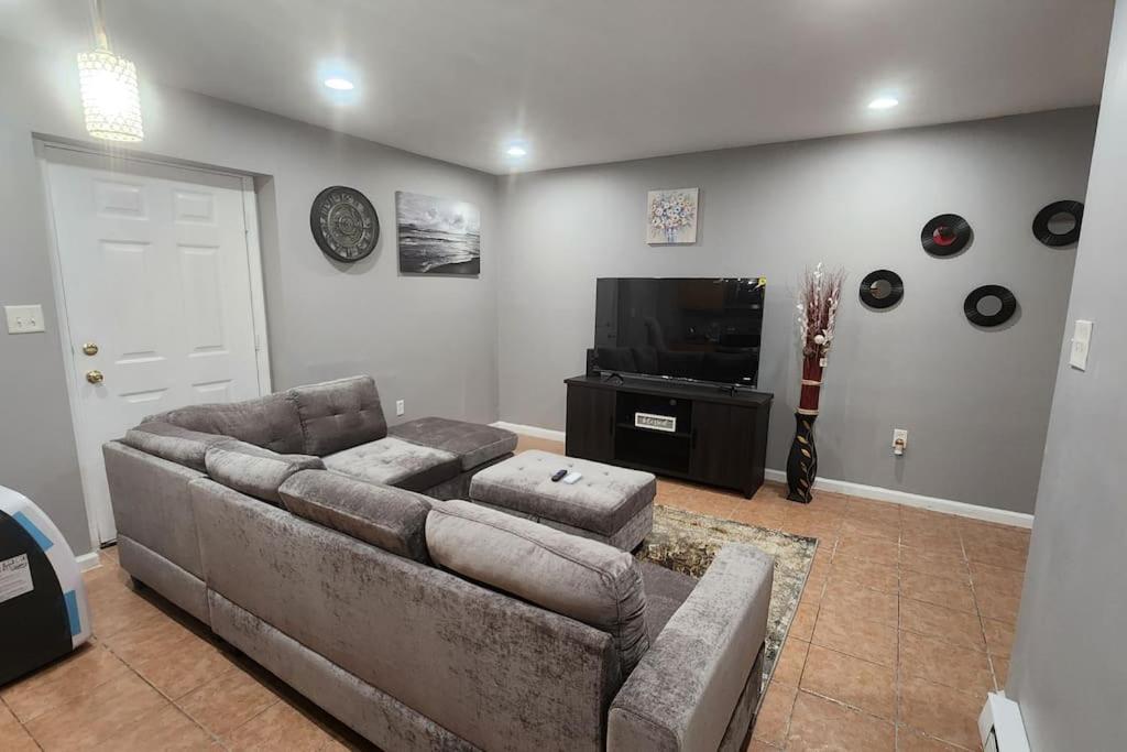 a living room with a couch and a flat screen tv at Cozy King Bed, Free Parking! in Newark