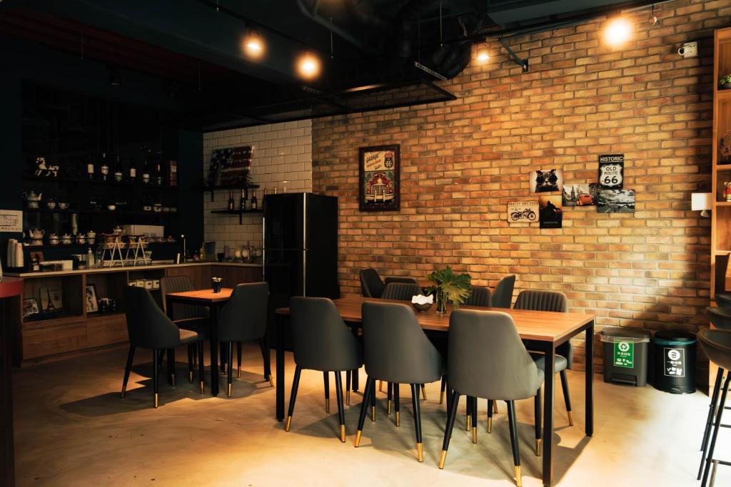 un restaurante con mesas y sillas y una pared de ladrillo en Jincheng Hostel, en Changhua County