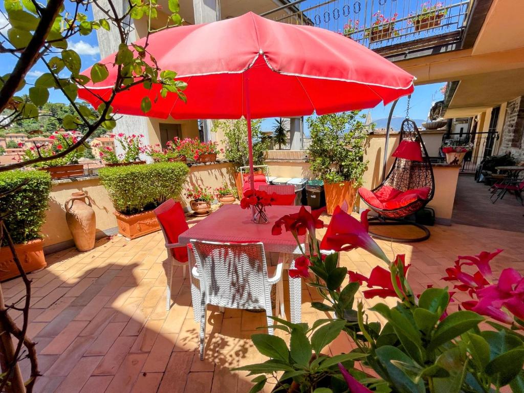 um pátio com uma mesa e um guarda-chuva vermelho em Terrazza Bella/sleeps 4/spoleto/car Not Necessary em Spoleto