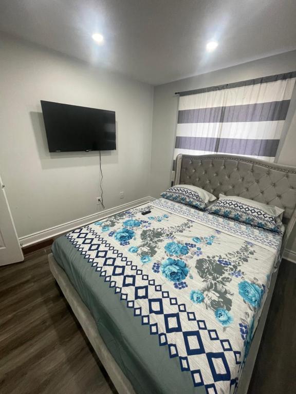 1 dormitorio con 1 cama y TV en la pared en Triple M Lodge Double, en Mississauga
