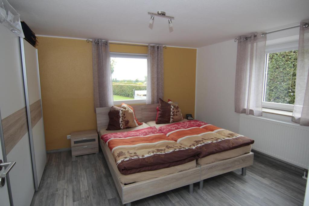 ein Schlafzimmer mit einem großen Bett und einem Fenster in der Unterkunft Ferienwohnung Margot in Simmerath