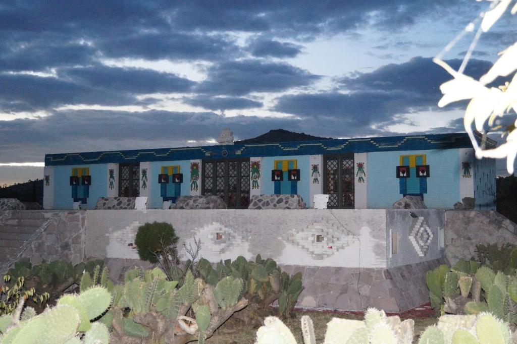 uma casa azul e branca com cactos à frente. em Hotel Casa de la Luna em San Juan Teotihuacán