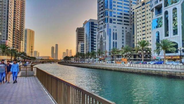 a river in the middle of a city with buildings at Happy nights in Sharjah