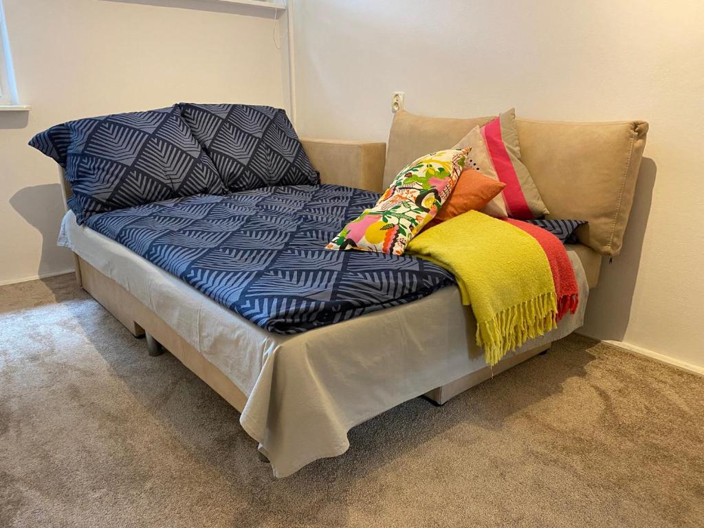 Broniewskiego Centrum Konin في كونين: سرير مع وسائد ملونة عليه في غرفة