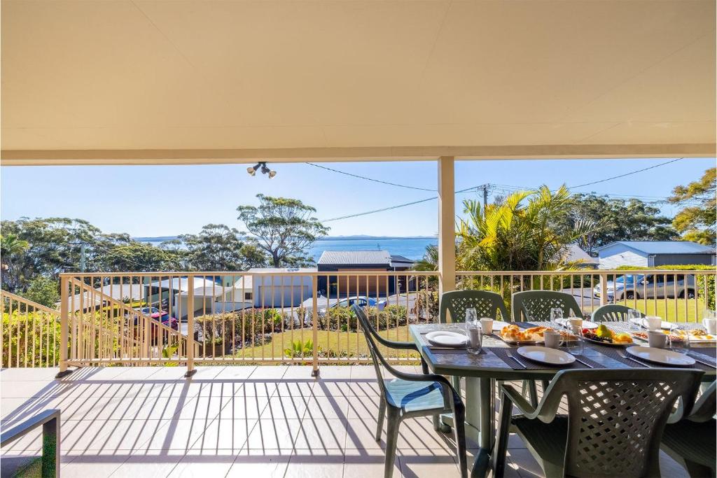 a table and chairs on a patio with a view at 33 Gloucester St -huge holiday house in Nelson Bay with Pool, Air Con, WiFi, Foxtel and Stunning Water Views in Nelson Bay