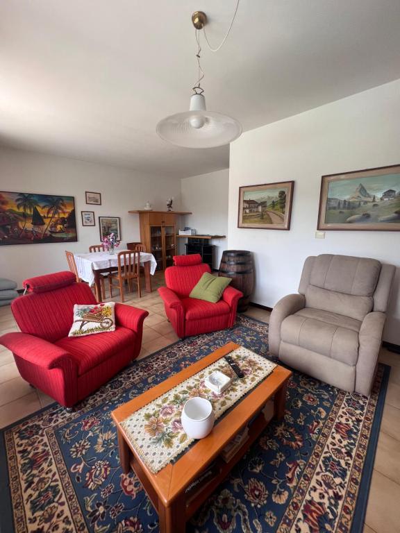 ein Wohnzimmer mit roten Stühlen und einem Tisch in der Unterkunft Appartamento CASA DEI NONNI 