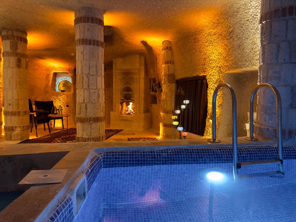 a swimming pool in a building with a fireplace at Angel View Suites in Goreme
