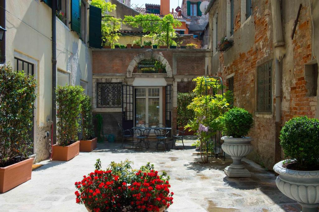 un cortile fiorito in vasi in un edificio di Savoia e jolanda Apartments a Venezia