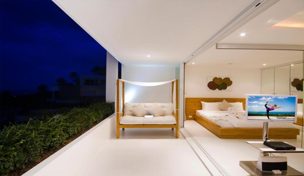 a bedroom with a bed and a couch and a table at Code Samui Hotel in Mae Nam
