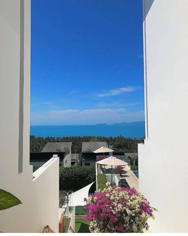 a view from the balcony of a house with flowers at Code Samui Hotel in Mae Nam