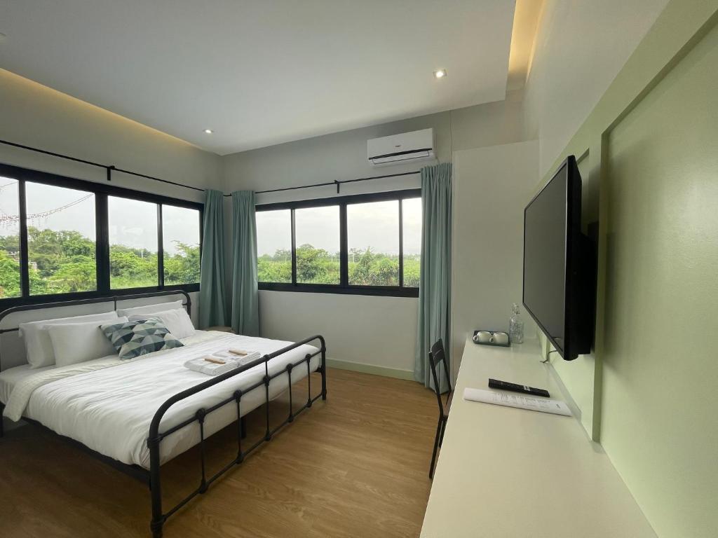 Casa Maria's Bed & Breakfast في Echague: غرفة نوم بسرير ومكتب مع تلفزيون