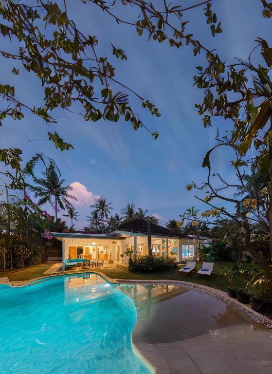 a swimming pool in front of a house at Secret Haven Cozy 3 Bedroom Private Pool Villa in Gili Trawangan