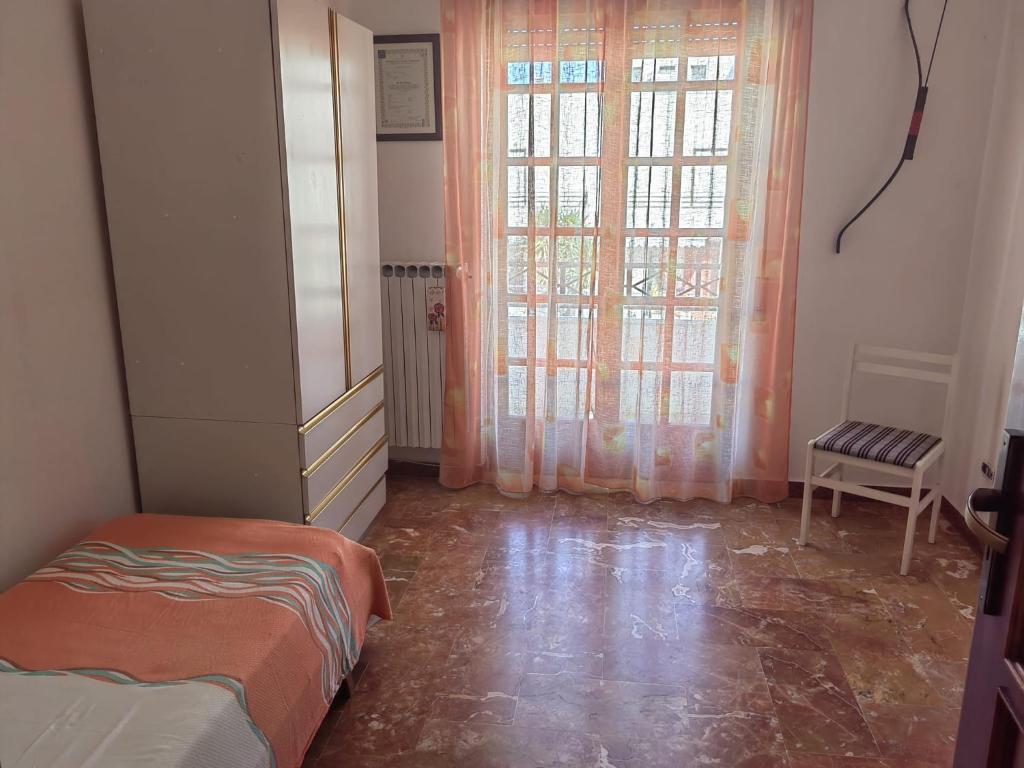 1 dormitorio con 1 cama y una ventana con cortinas en Appartamento Ida vacanza mare en Policoro