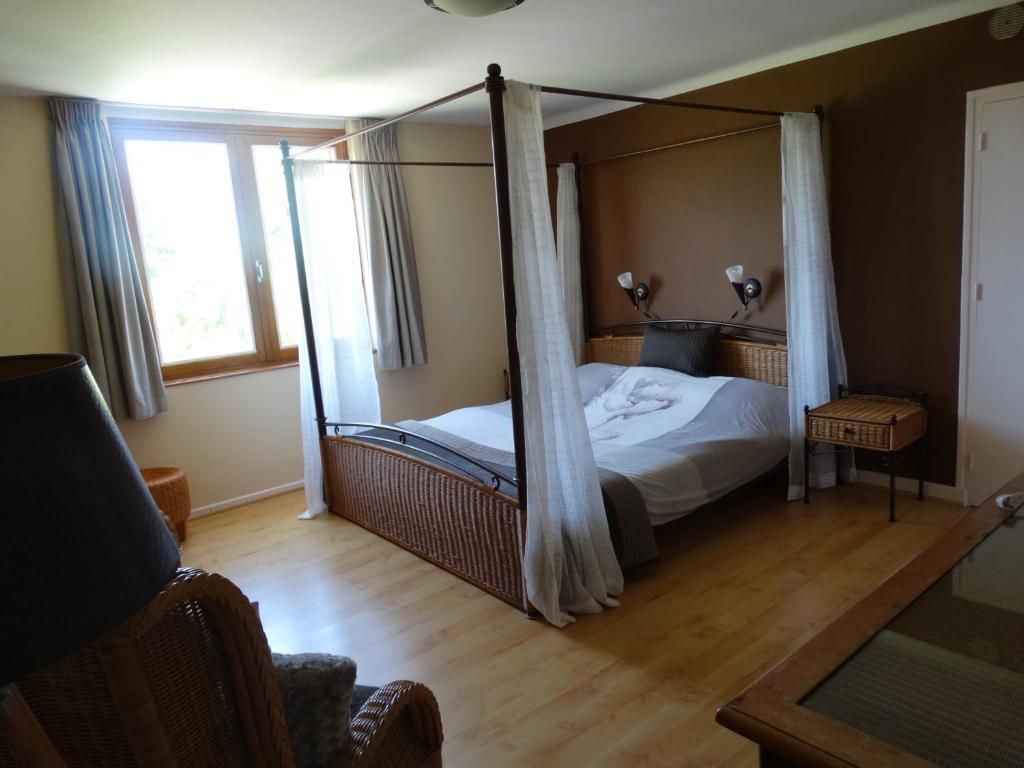 a bedroom with a bed with a canopy at L'Enclos B&B in Châtillon-en-Diois