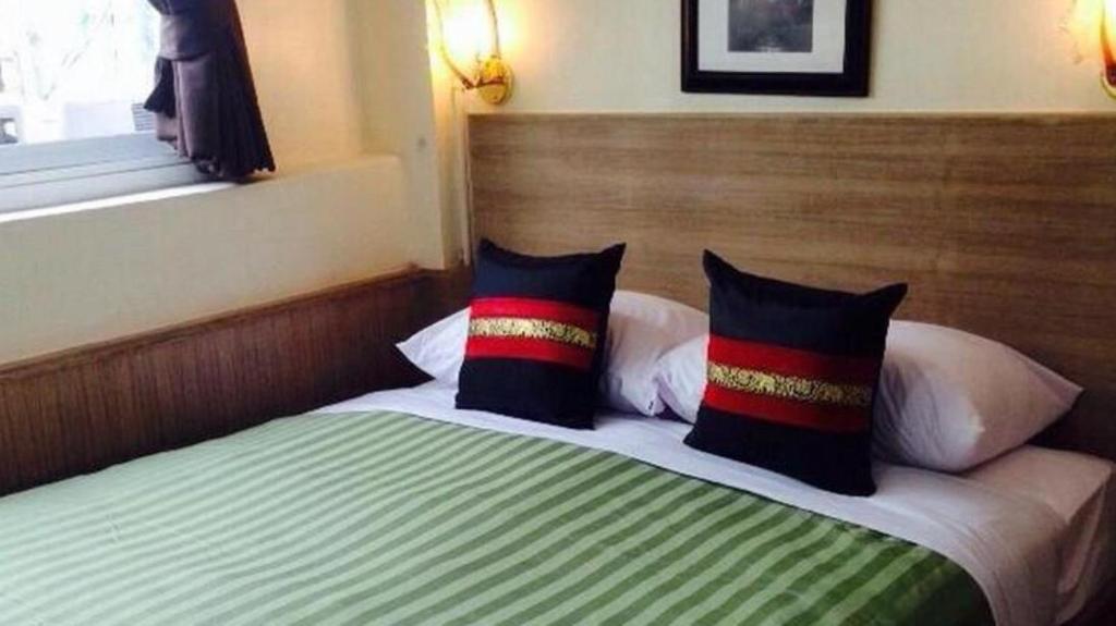 um quarto com uma cama com duas almofadas em Sukhumvit 20 Guest House em Bangkok