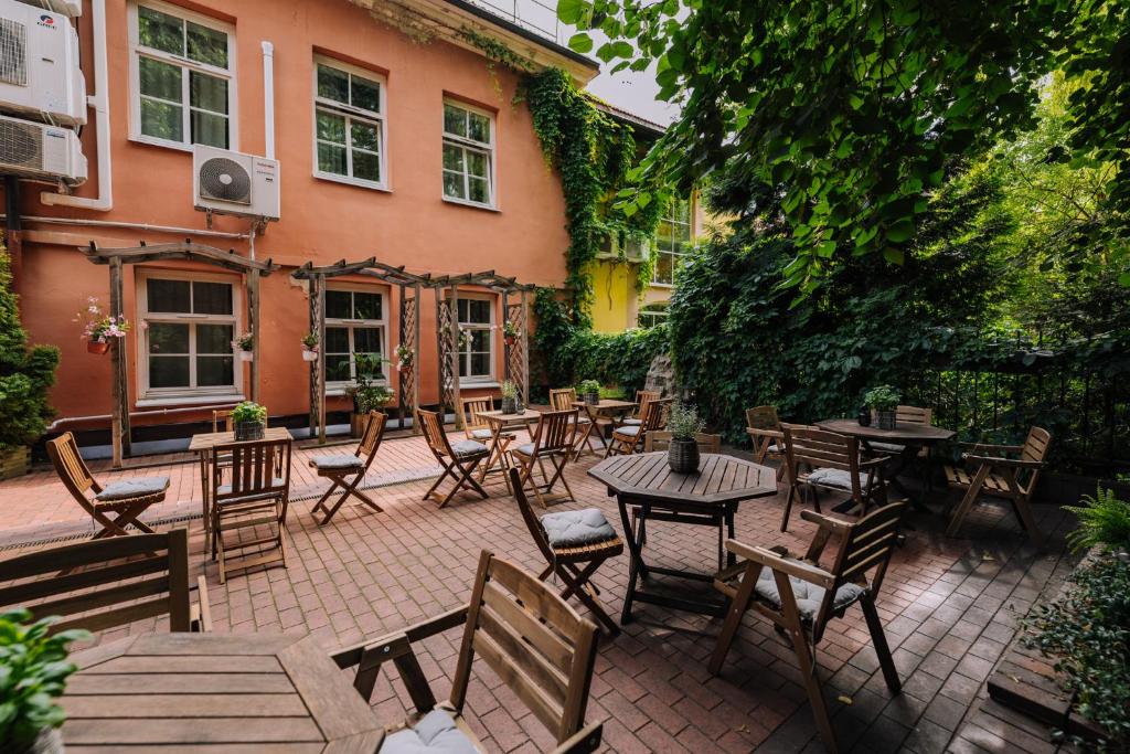 eine Terrasse mit Tischen und Stühlen vor einem Gebäude in der Unterkunft Hotel Rinno in Vilnius