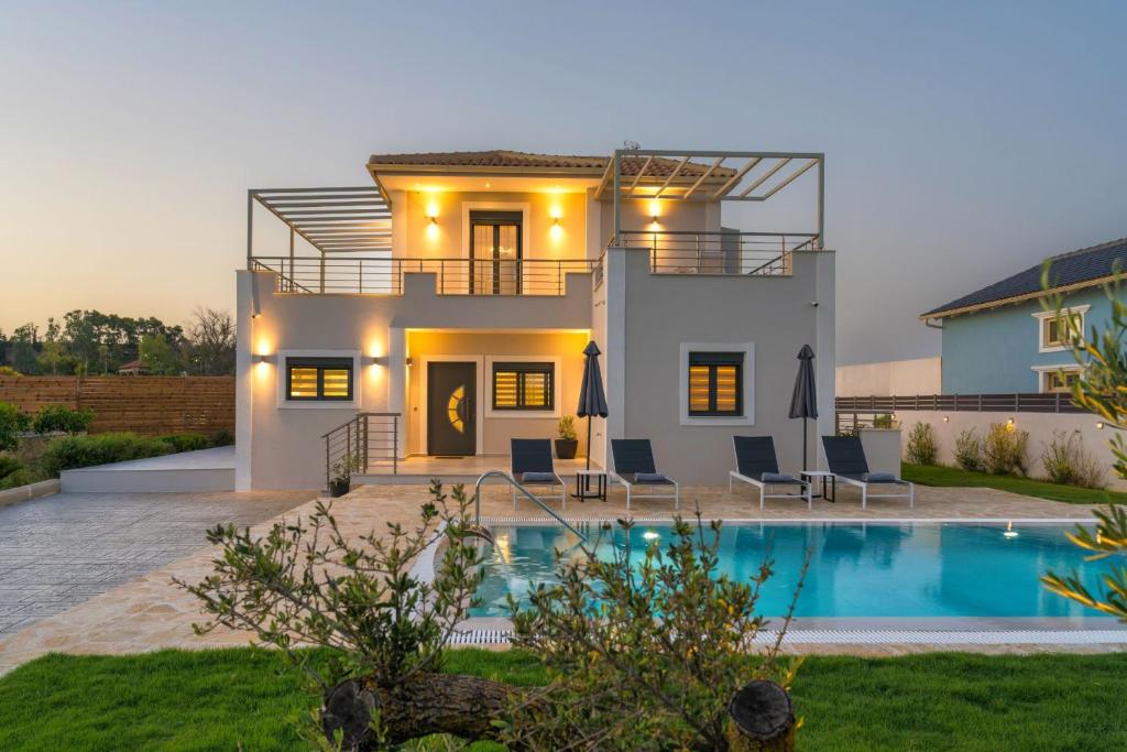 a villa with a swimming pool in front of a house at Villa Debora in Zakynthos Town