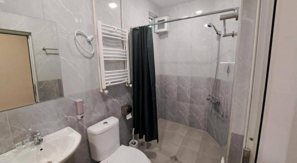 a bathroom with a shower and a toilet and a sink at Kai Hotel in Tbilisi City