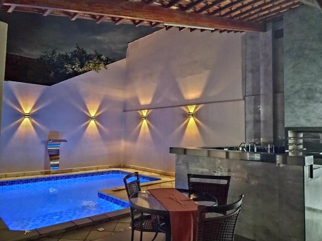 una piscina en un patio con mesa y sillas en Piscina Aquecida, Ar condicionado Casa Inteira,Caminhos da Canastra, en São João Batista do Glória