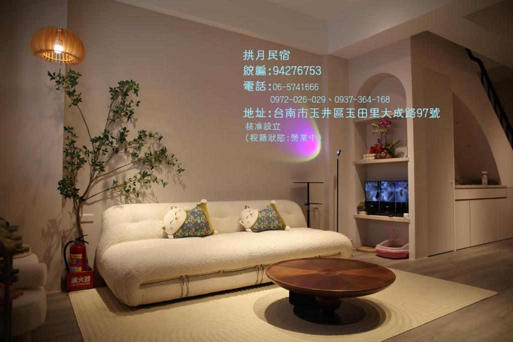 salon z kanapą i stołem w obiekcie 玉井拱月民宿 w mieście Yujing