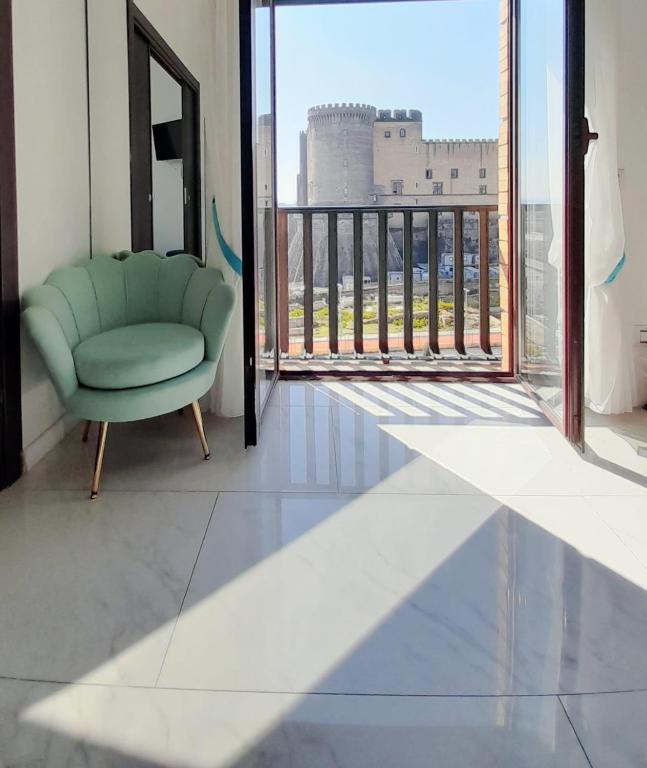 a green chair in a room with a large window at Babylon Luxury Suite & Apartments in Naples