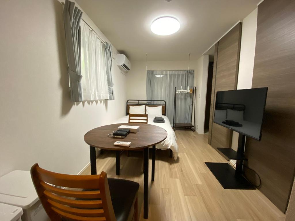 a small living room with a table and a television at EveryNet Shinjuku by Tranova in Tokyo