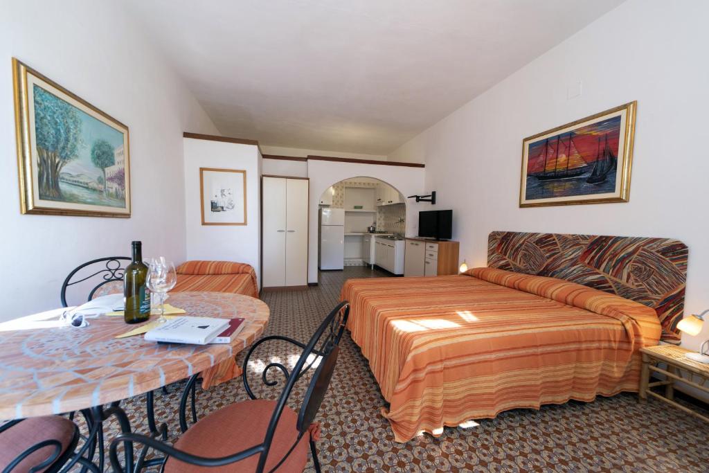 a living room with a bed and a table and a couch at Gavila's Residenza Turistico Alberghiera in Porto Azzurro