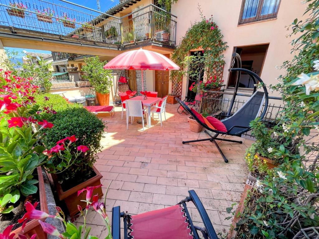 eine Terrasse mit einem Tisch, Stühlen und einem Sonnenschirm in der Unterkunft Spoleto Bellasleeps 4 - 4 in Spoleto