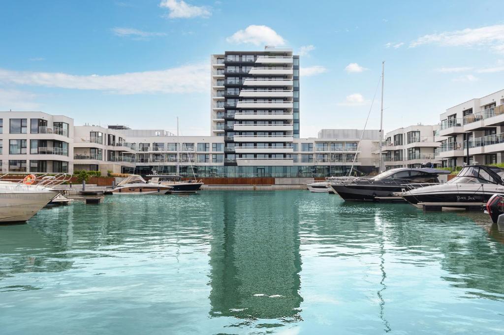 una masa de agua con barcos delante de los edificios en GRANO HOTEL Solmarina en Wiślinka