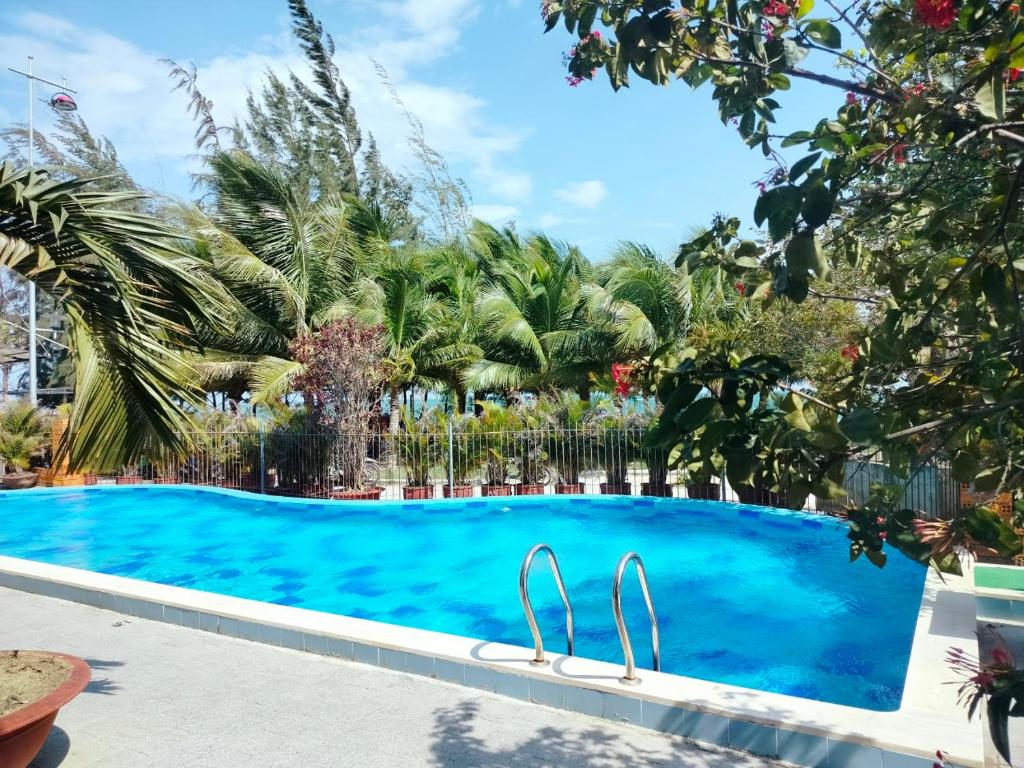 Phuc Thuan Hotel في فان رانغ: مسبح في منتجع فيه نخل