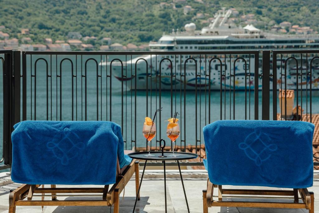 two chairs and a table on a balcony with a cruise ship at Boutique Hotel Casa del Mare - Vizura in Kotor
