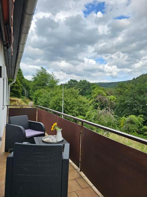 a balcony with two chairs and a table with a view at Große Ferienwohnung am Waldrand in Schönau