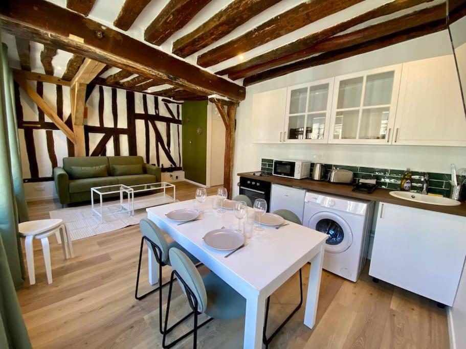 a kitchen with a white table and chairs in a room at L’Eucalyptus in Rouen