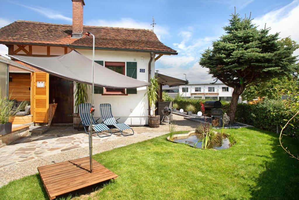 a patio with a white umbrella in a yard at die Bahnstation in Friedrichshafen