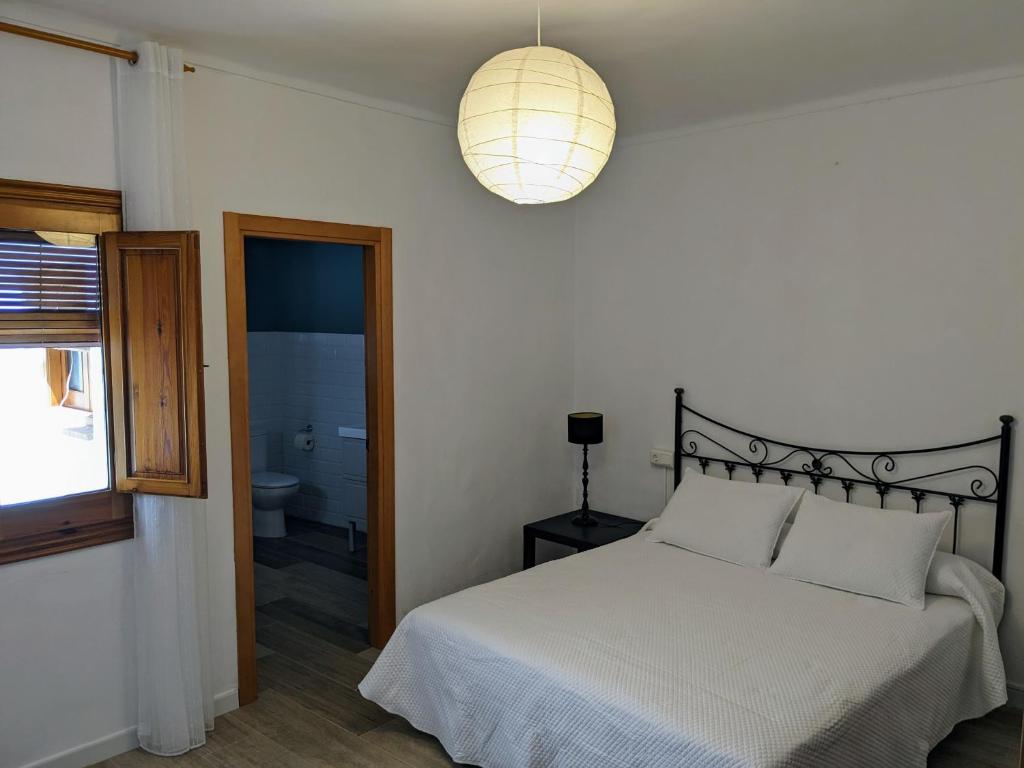 1 dormitorio con 1 cama y luz colgante en Casa Malena - Biar, en Biar