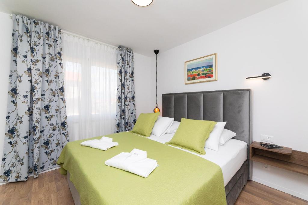 - une chambre dotée d'un grand lit avec des draps verts dans l'établissement Deluxe apartment BRAČOLET private pool, à Supetar