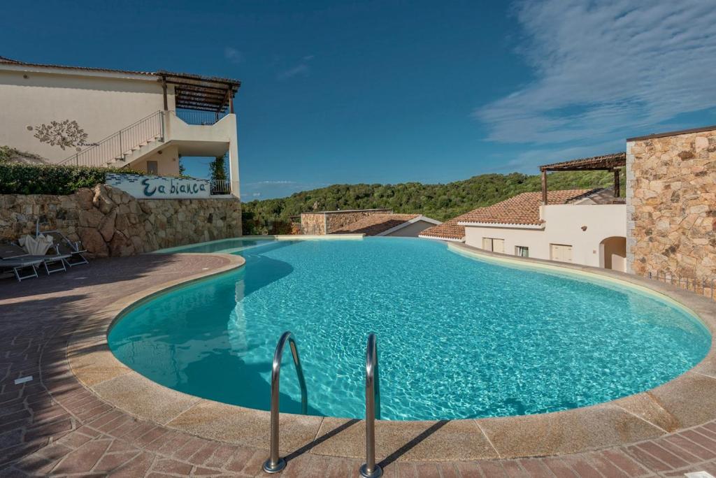 una gran piscina en medio de una casa en ISA-Residence with swimming-pool just 4 km from Baja Sardinia, apartments with outdoor private space and air conditioning, en Cala Bitta