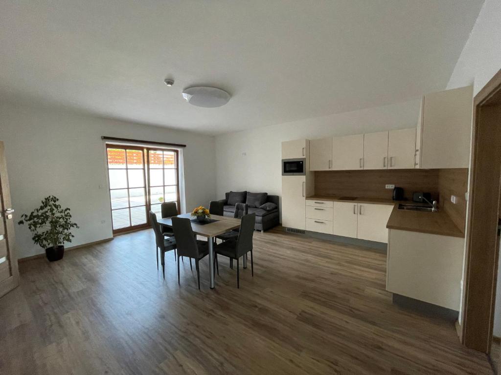 Apartmány Lipka في فيمبيرك: غرفة معيشة مع طاولة وكراسي ومطبخ