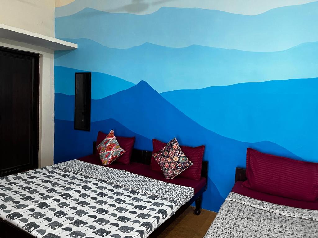 Habitación con 2 camas y pared azul en Wild Mountain Homestay, en Rishīkesh