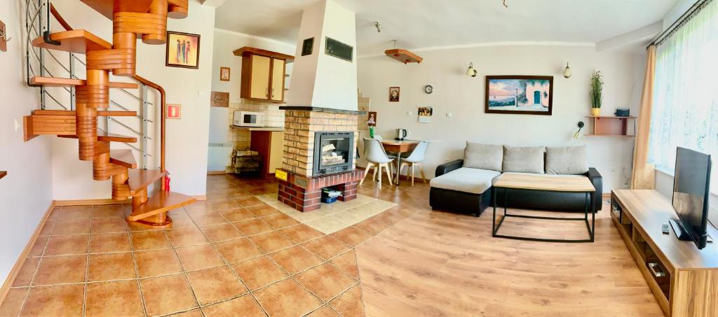 a living room with a couch and a fireplace at Fonica - Domek Apartament in Łeba