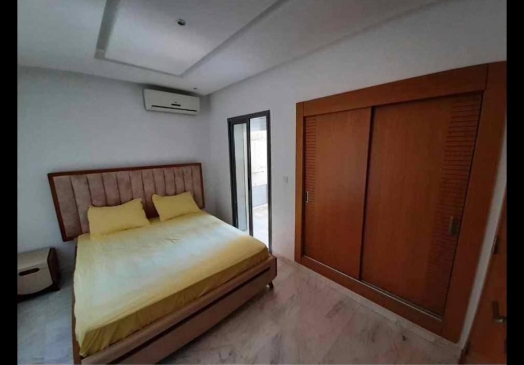 um quarto com uma cama e uma porta de madeira em Panamera vue mer 180 degré em Sousse
