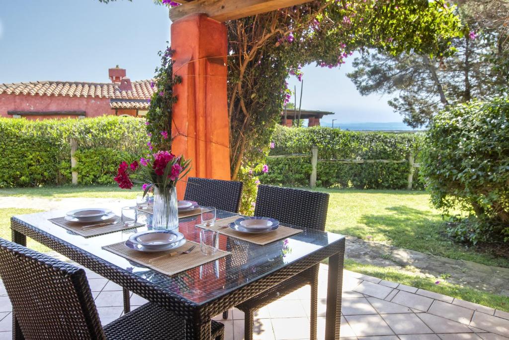 a table with chairs and flowers on a patio at Villa Toni in Stintino