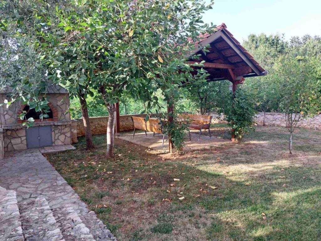 a garden with a pavilion and a bench and trees at Apartmani Neda in Čitluk