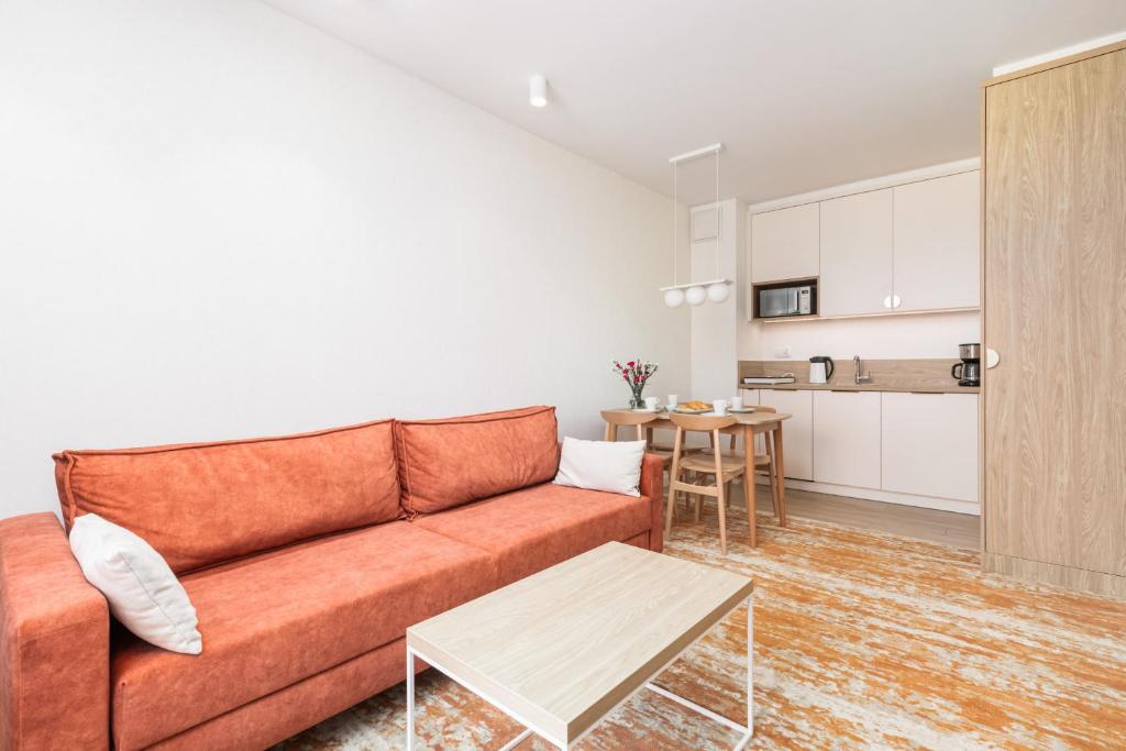 uma sala de estar com um sofá e uma mesa em Sun & Beach Apartments Bel Mare with Parking by Renters em Międzyzdroje