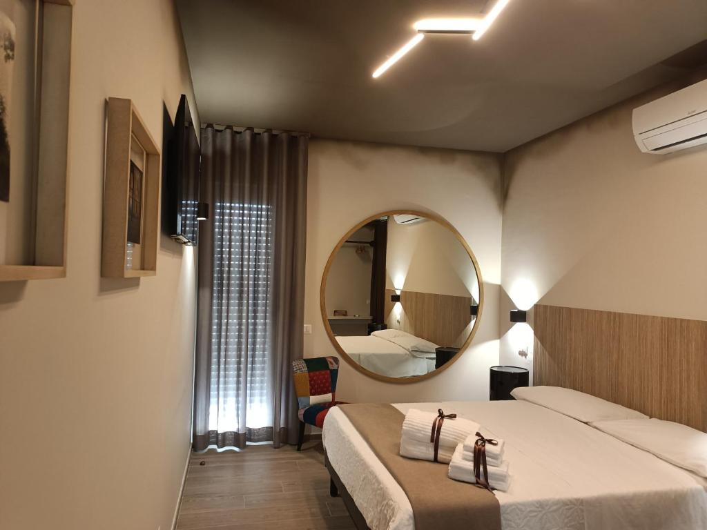SOHO B&B في فيشانو: غرفة نوم بسرير كبير ومرآة
