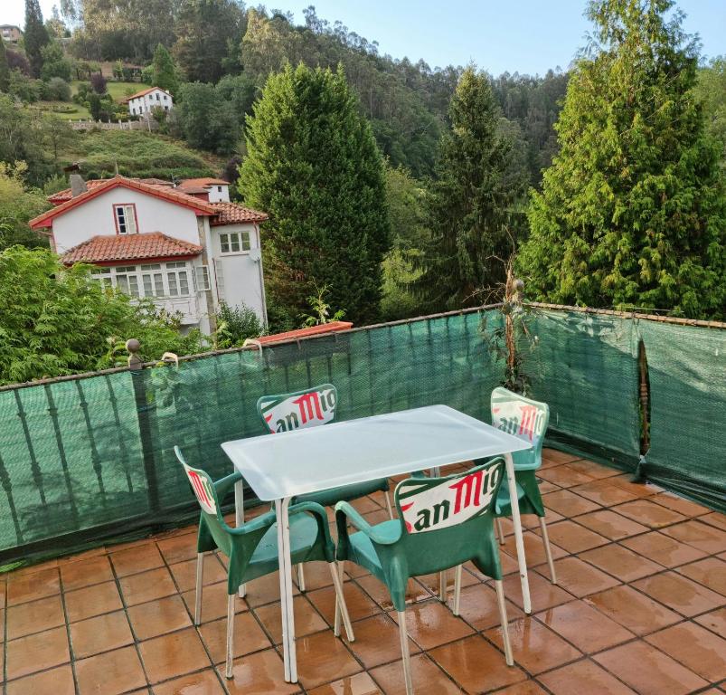 ein Tisch und Stühle auf einem Balkon mit Aussicht in der Unterkunft Corias Casona junto al Narcea in Corias